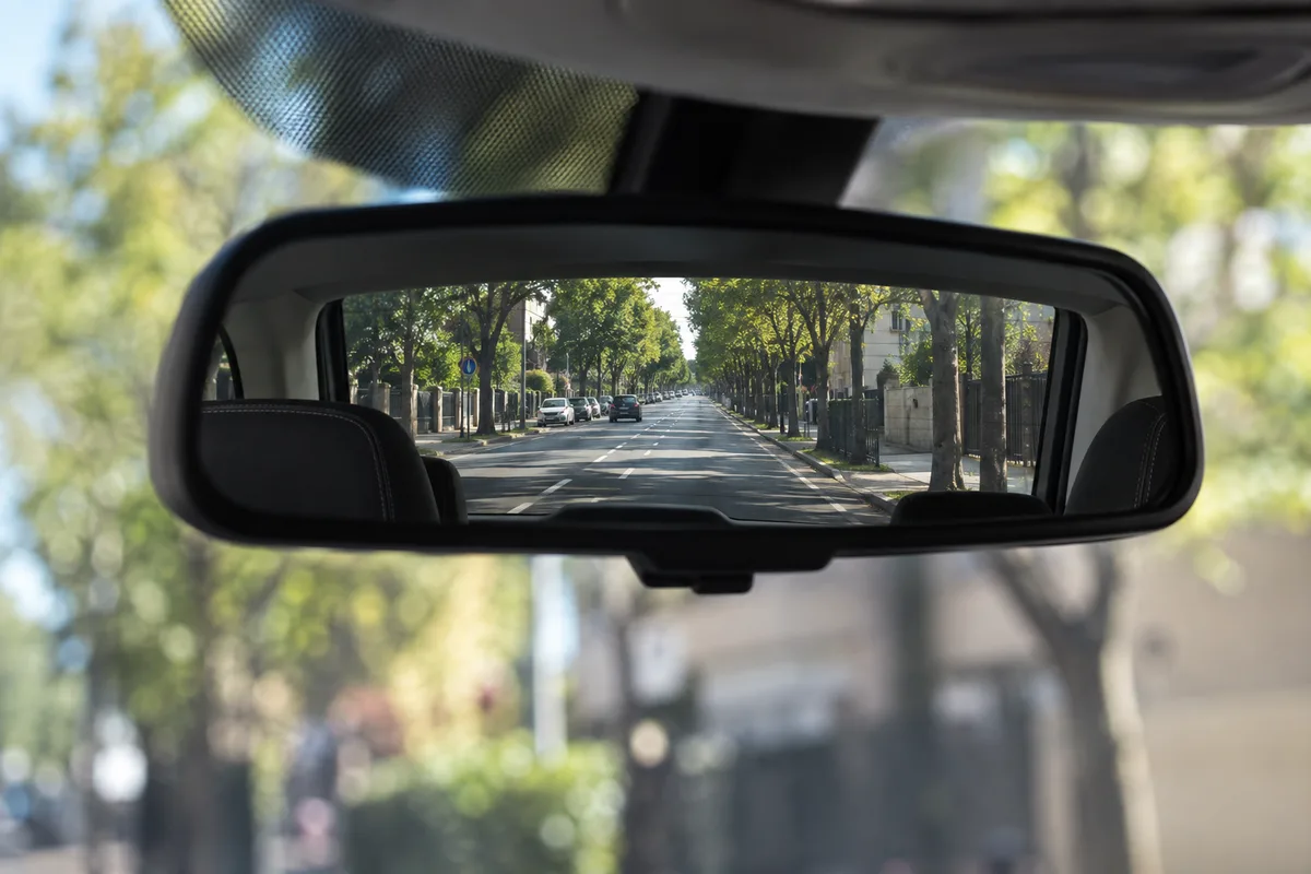 Rétroviseur intérieur reflétant une route dégagée derrière la voiture